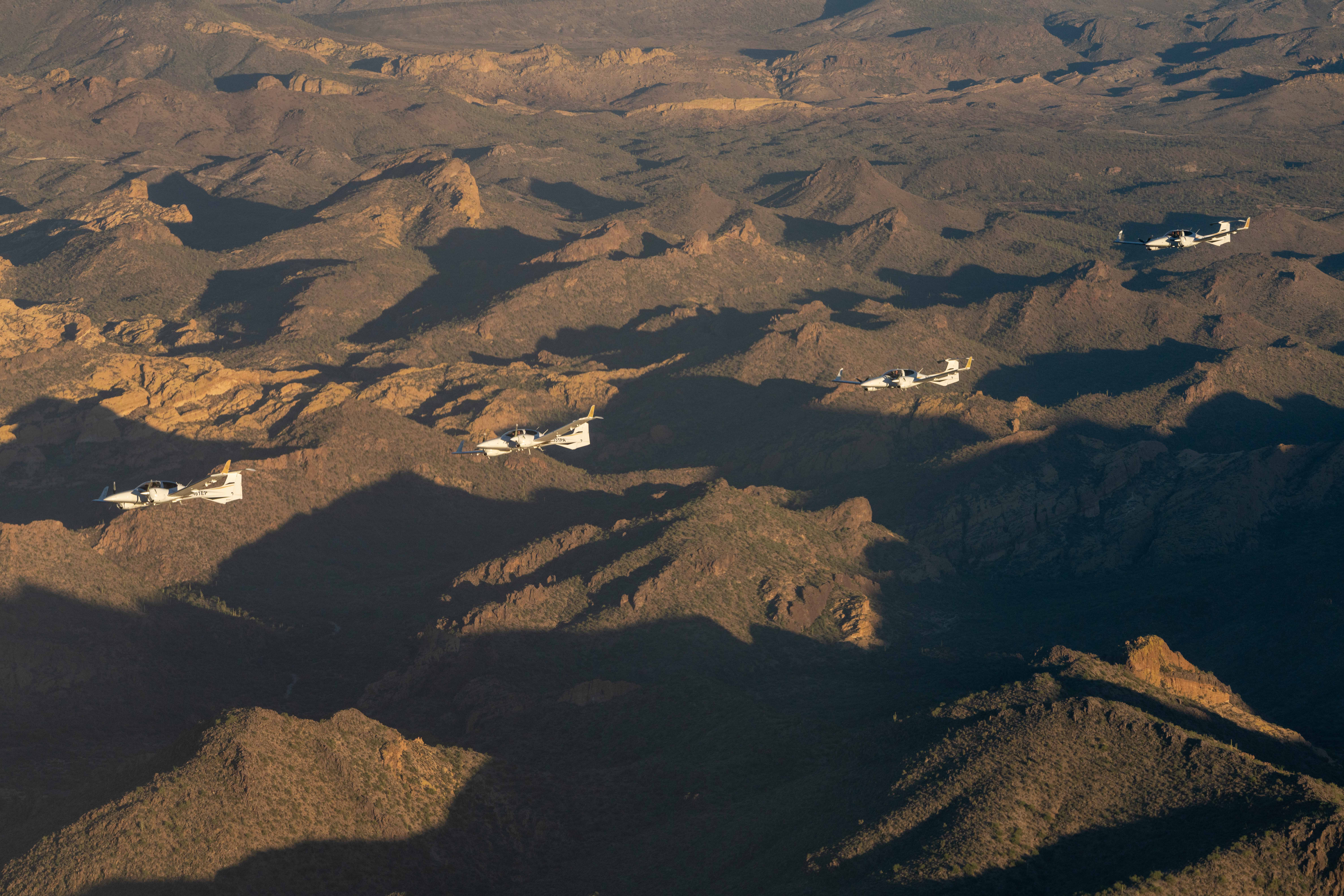Three Diamond DA42s in formation over the Sonoran mountains