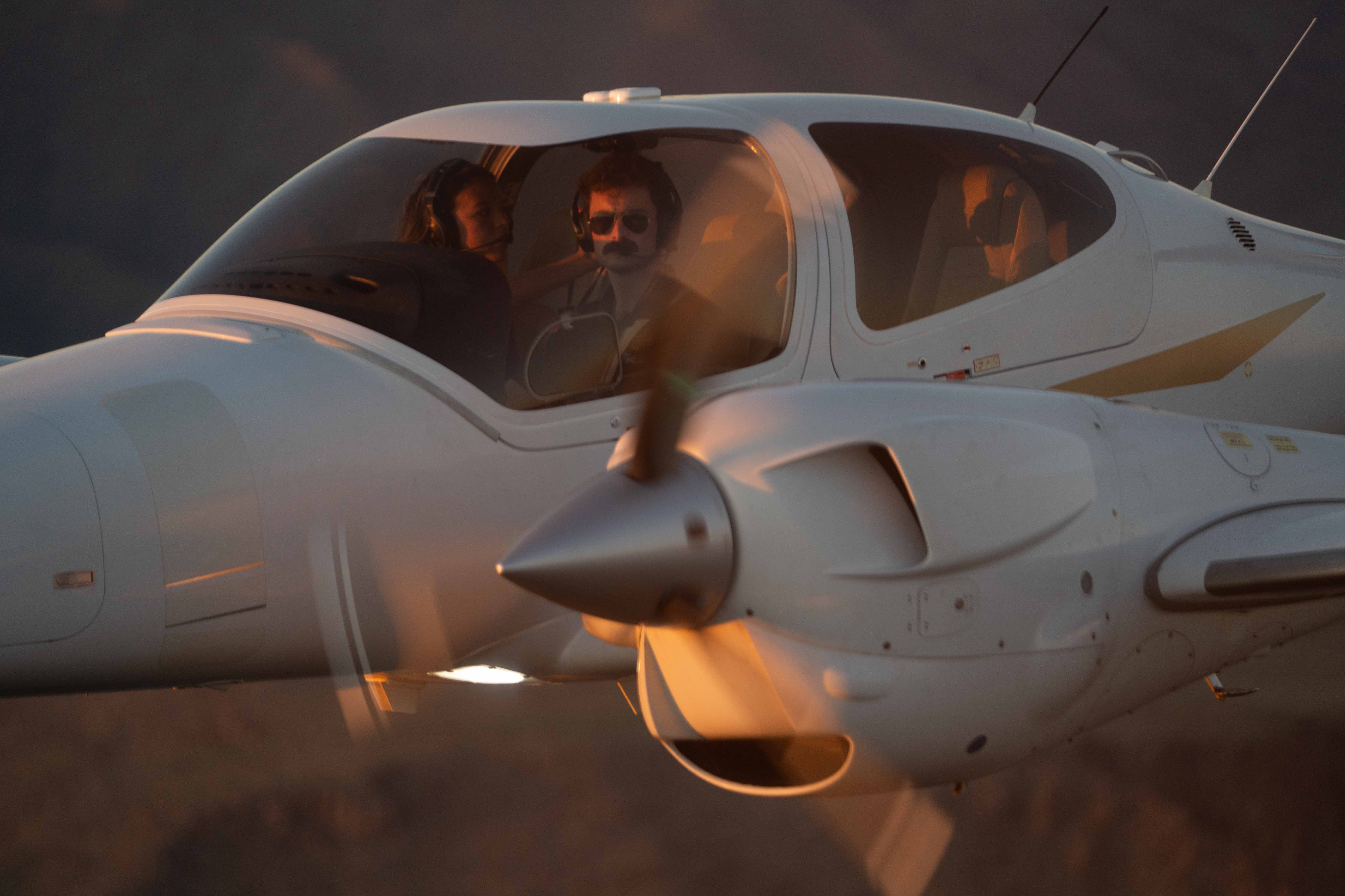 Air-to-air cockpit close-up of a Diamond DA42 at golden hour
