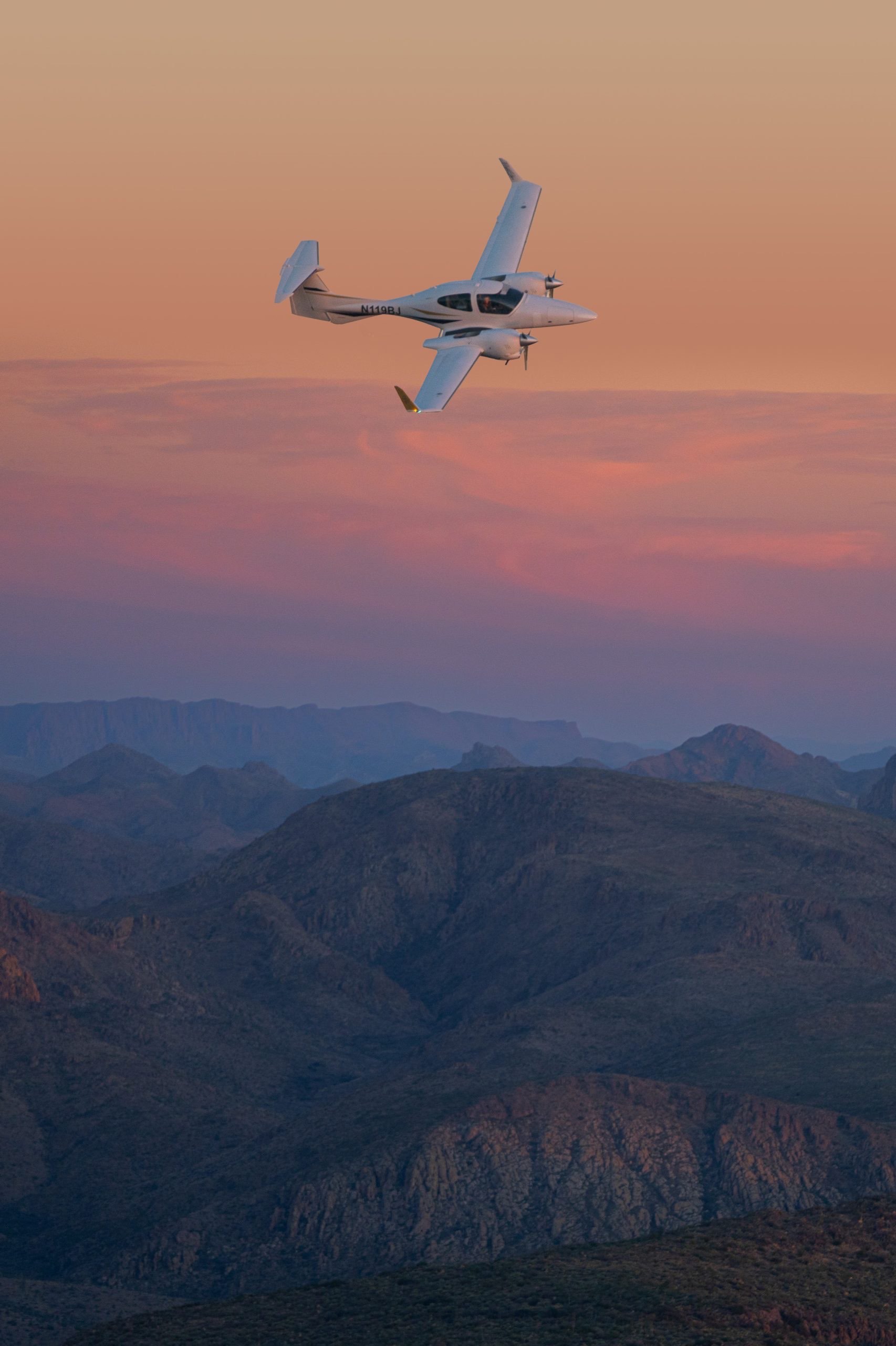 DA42 over the mountains at sunset, east of Mesa, Arizona