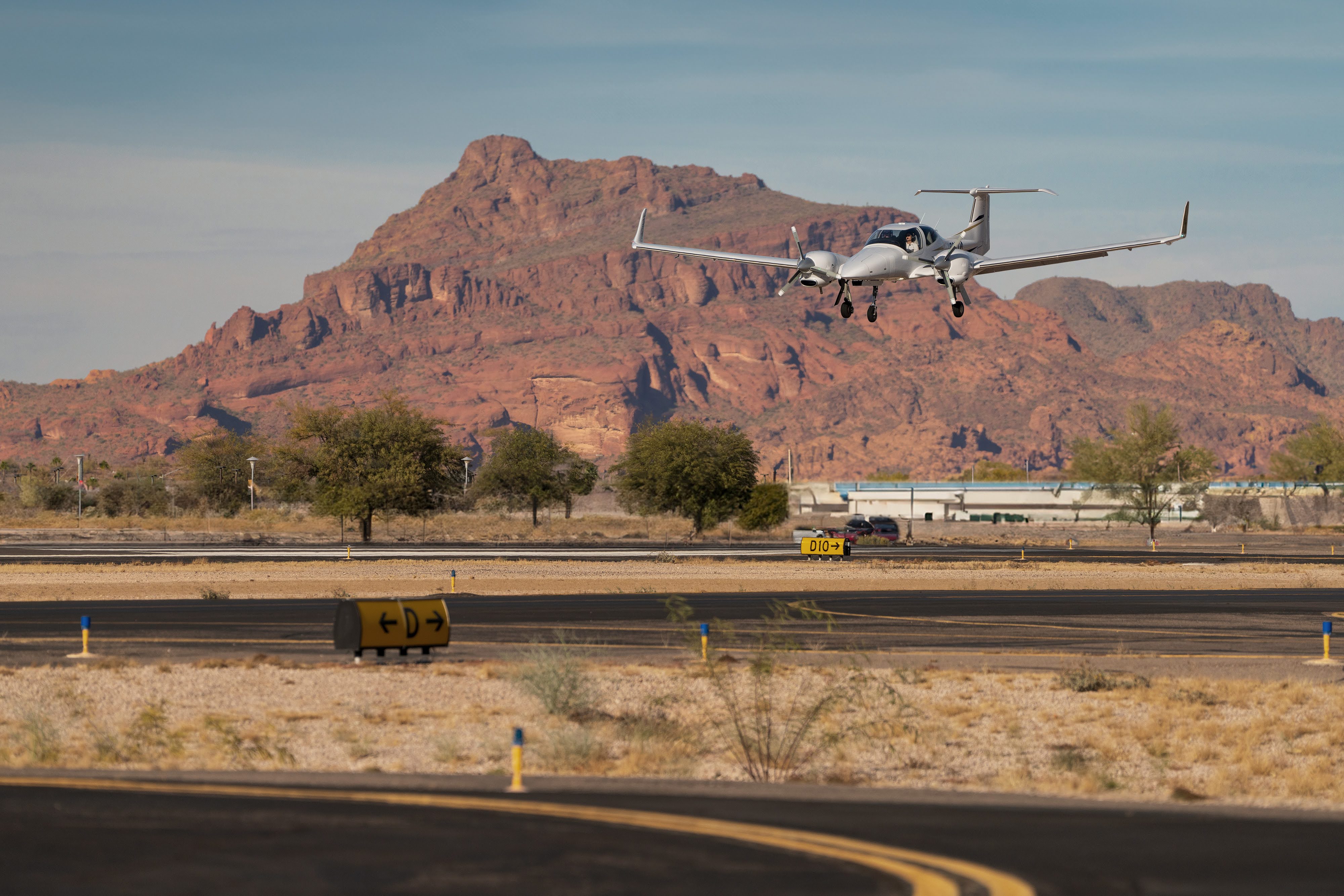 Diamond DA42 landing at Falcon Field Airport with Red Mountain in the background